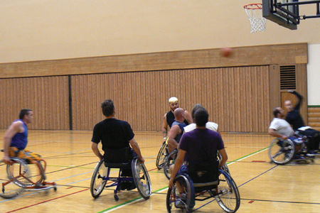 A group of man in wheelchairs playing basketball