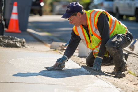 Man finishes the surface of a sidewalk