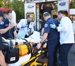 Image of Bellevue Fire Paramedics and firefighters lifting a patient into a medic unit. 