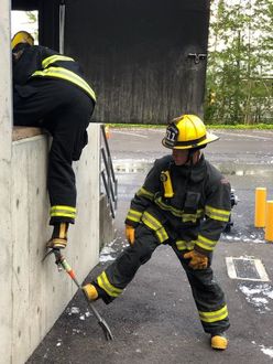 Fire Explorer stabilizing partner as he goes into window