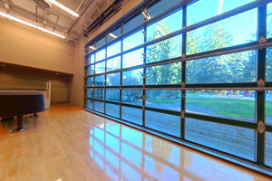 Image of CCC theatre - on stage, viewing piano and windows looking onto Crossroads Park